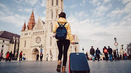 young woman dragging suitcase behind her