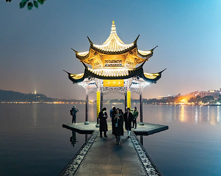 pagoda lit with lake at dusk in background