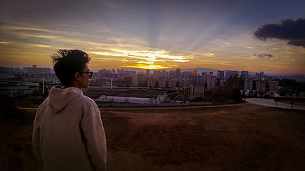 boy overlooking kunming cityscape at dawn